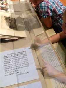 Kids examining a 19th-century Chinese labour contract, Celestial City exhibition